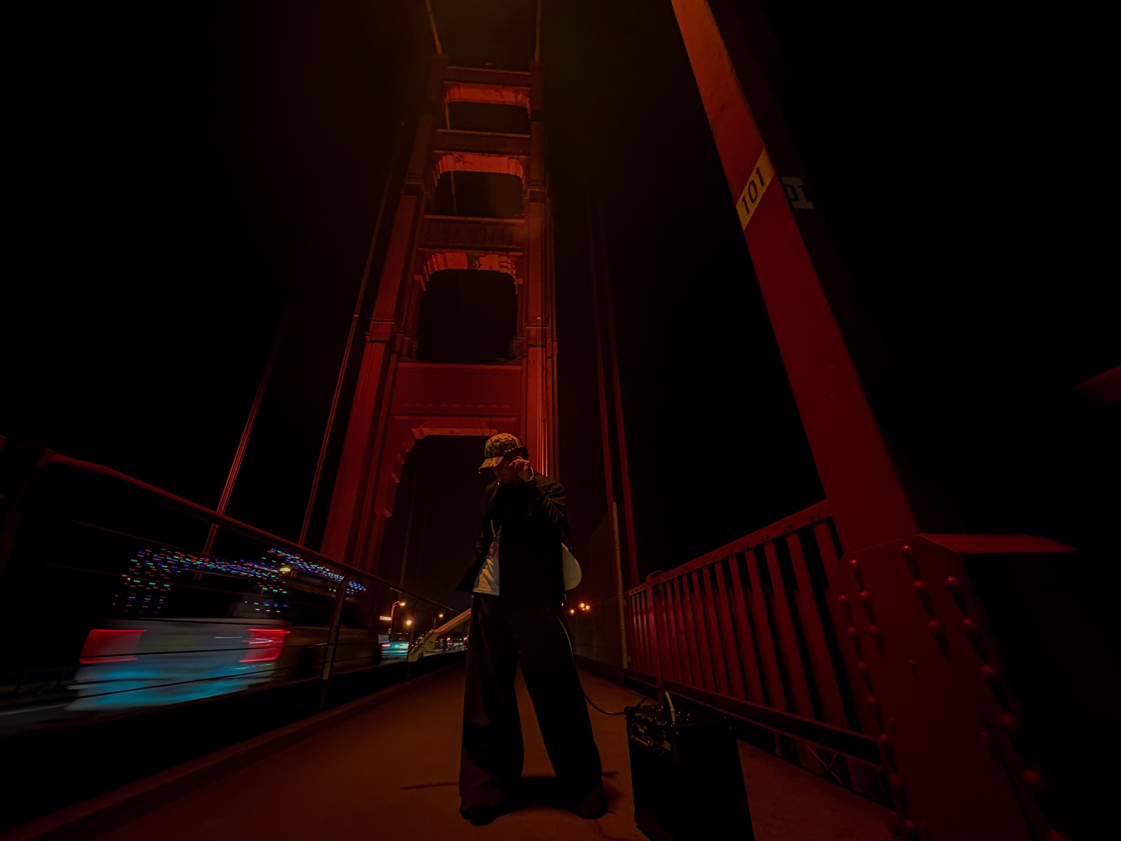 Arian Chandra standing beneath the Golden Gate Bridge at night