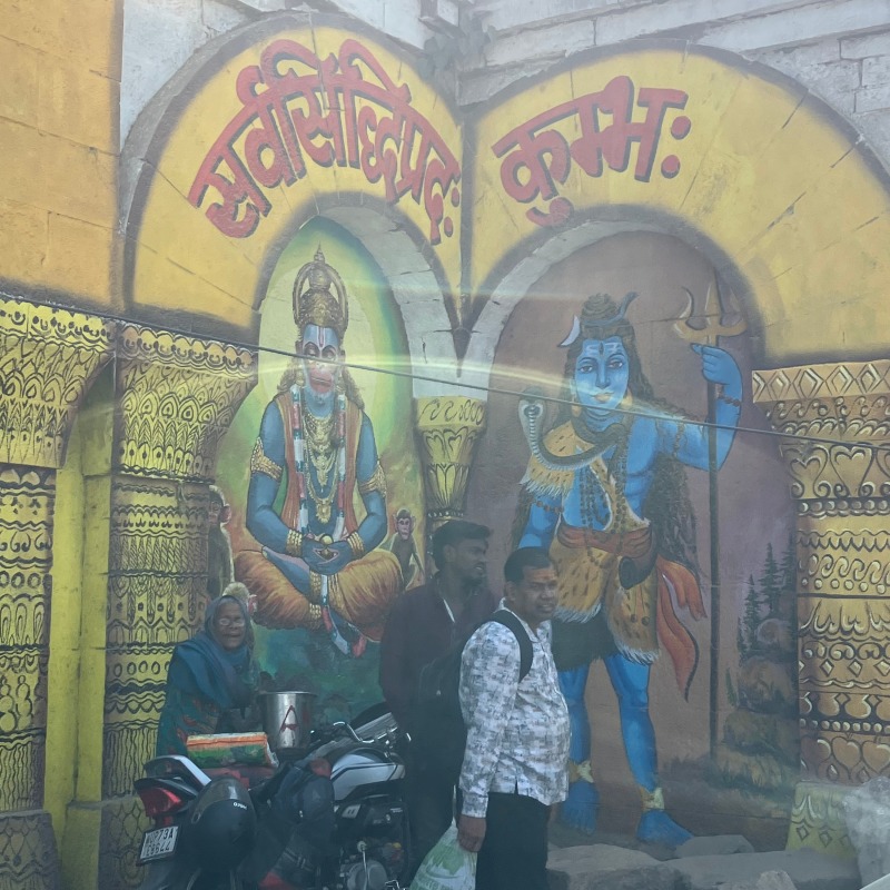 Sanctuary cover artwork showing a street scene and devotional mural in India